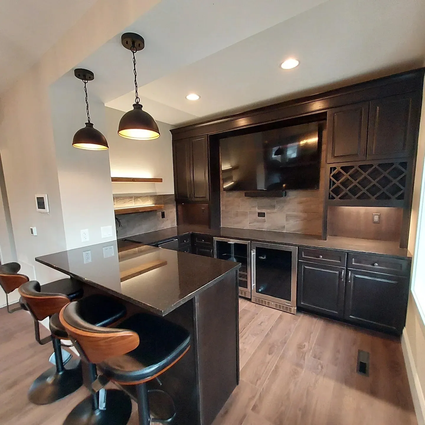 A kitchen with a bar and two stools