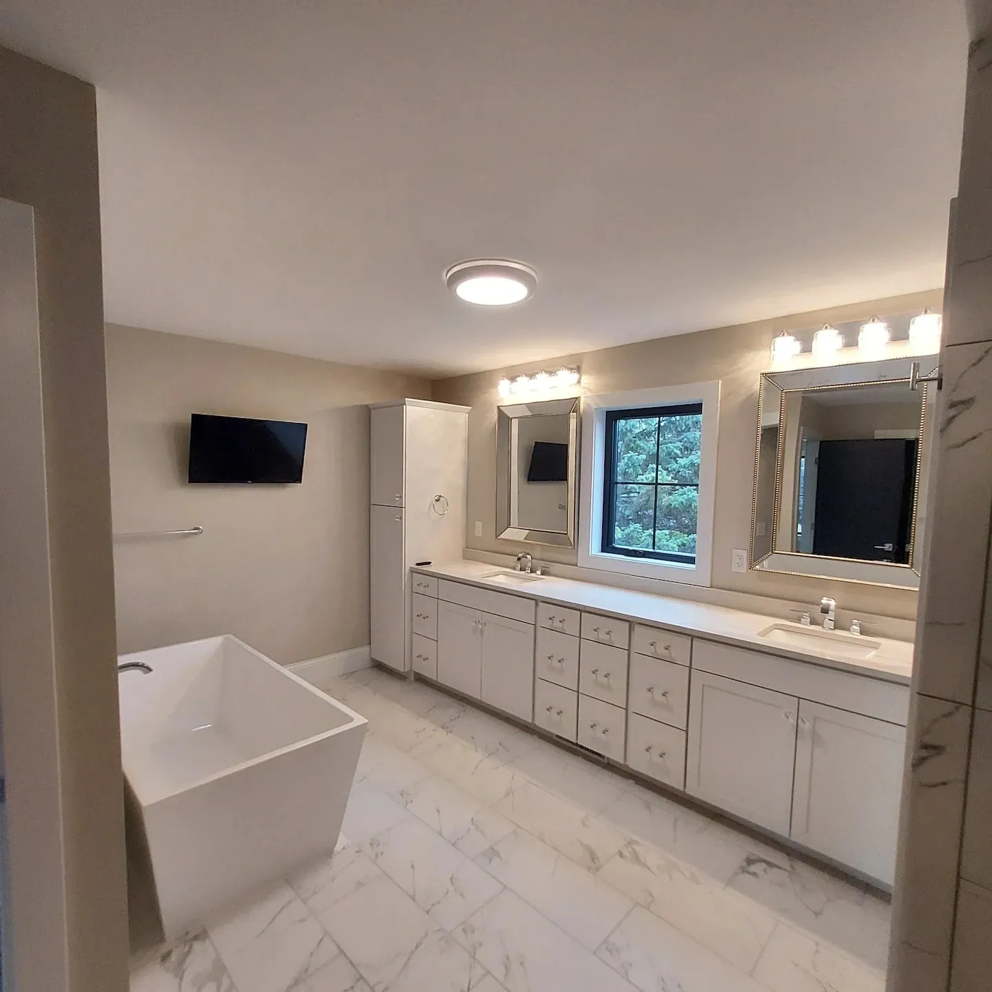 A bathroom with two sinks and a tub.