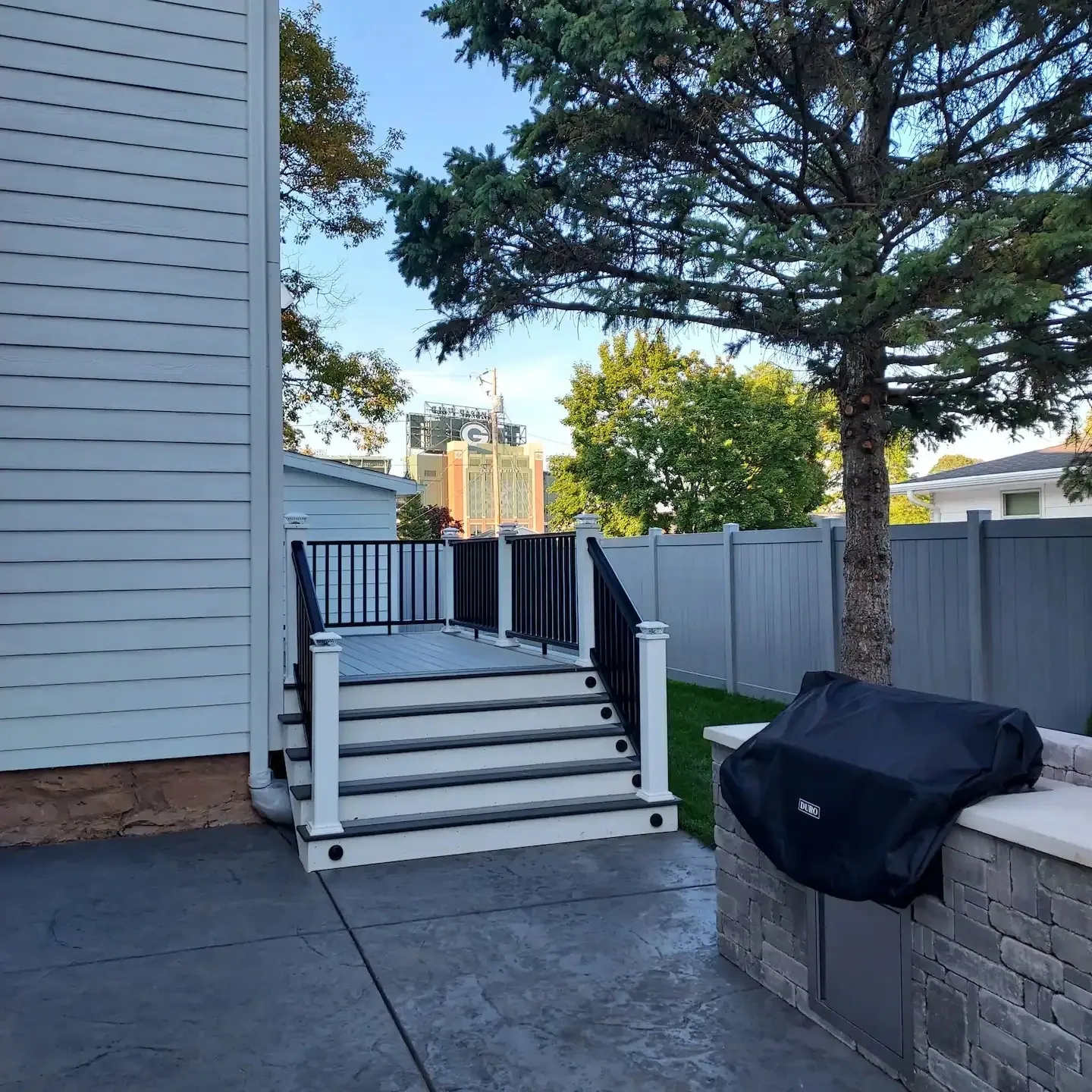 A patio with stairs leading to the back yard.