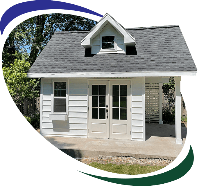 A white shed with a green background and trees