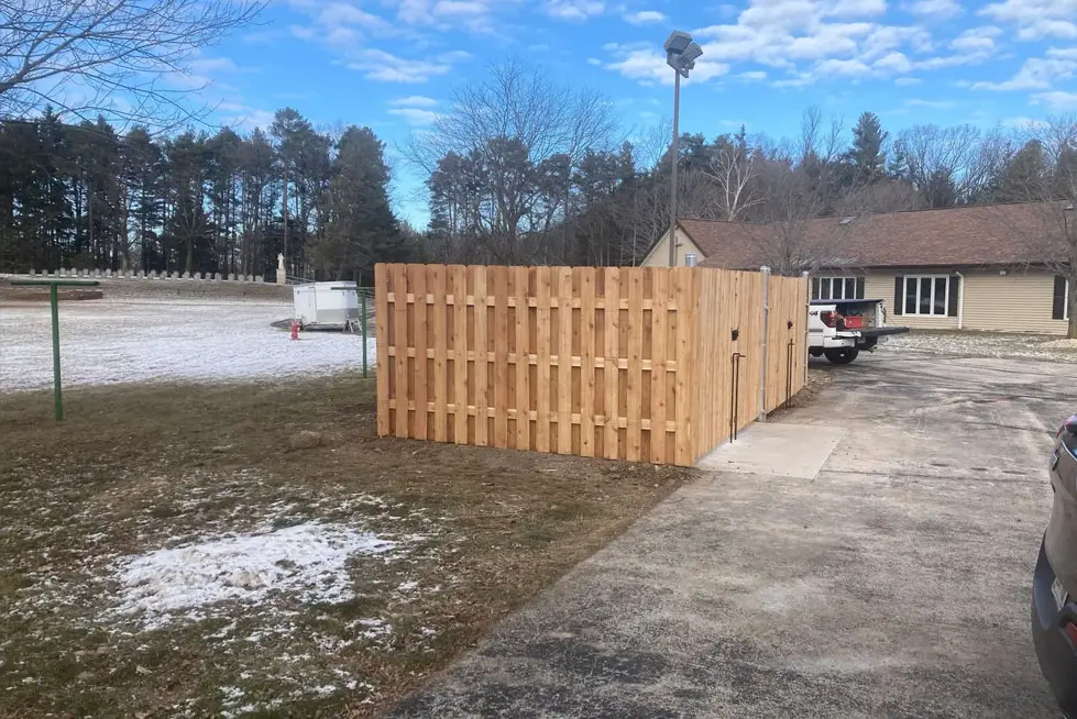 A wooden fence sitting in the middle of a driveway.